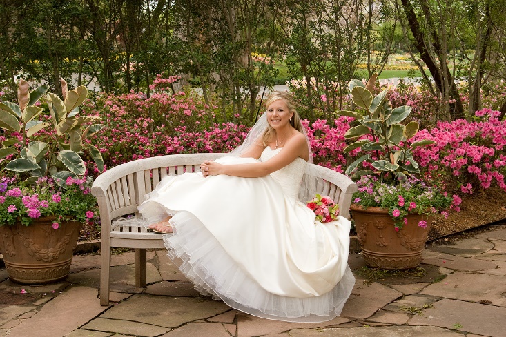 A person in a wedding dress sitting on a bench

Description automatically generated