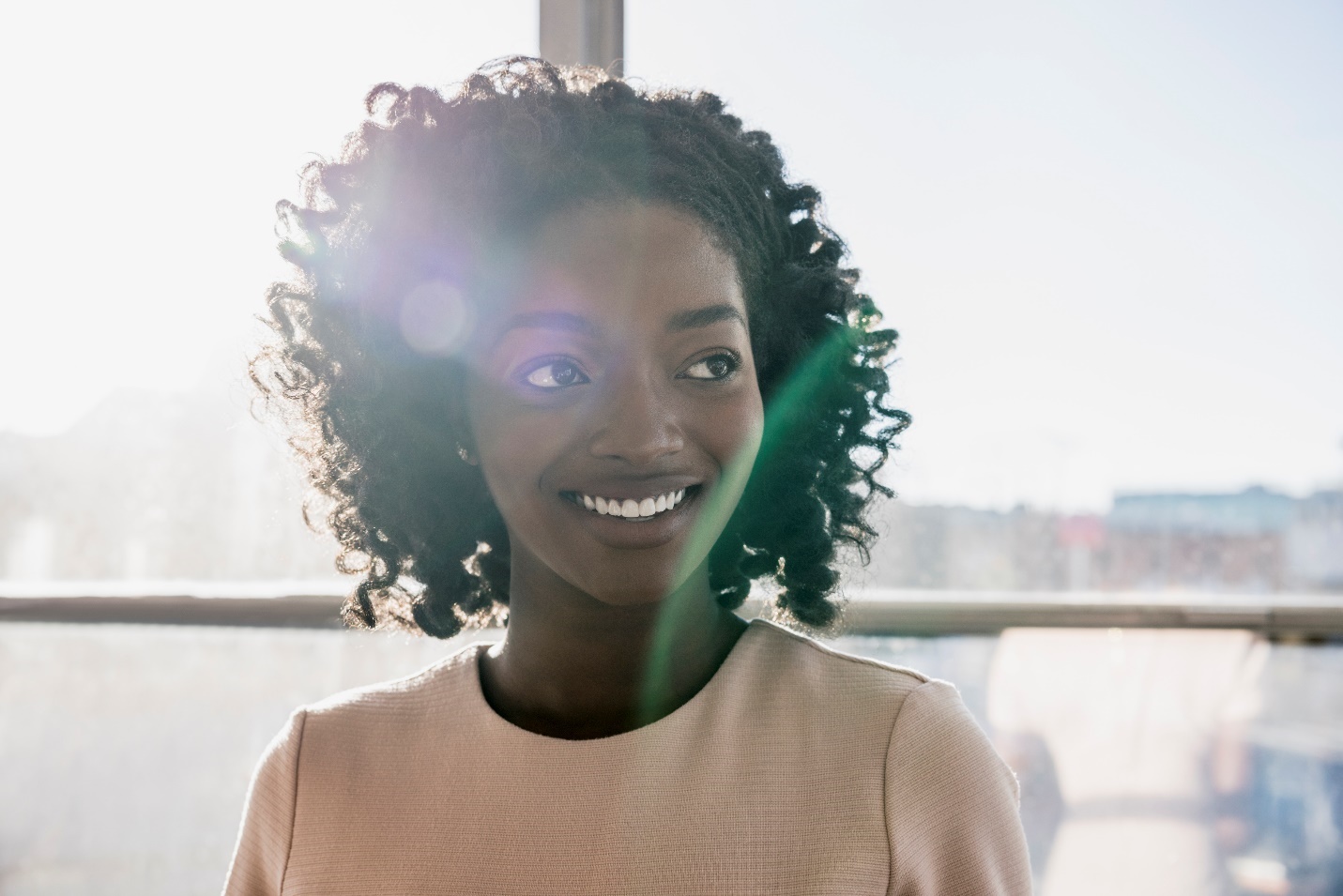 A person smiling in front of a window

Description automatically generated