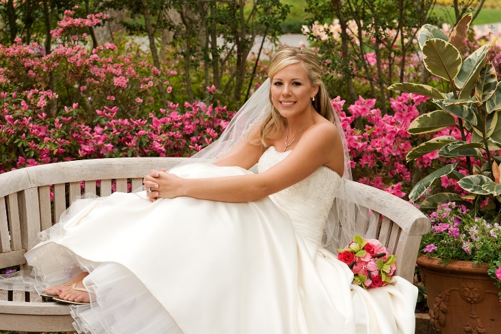 A person in a wedding dress sitting on a bench

Description automatically generated